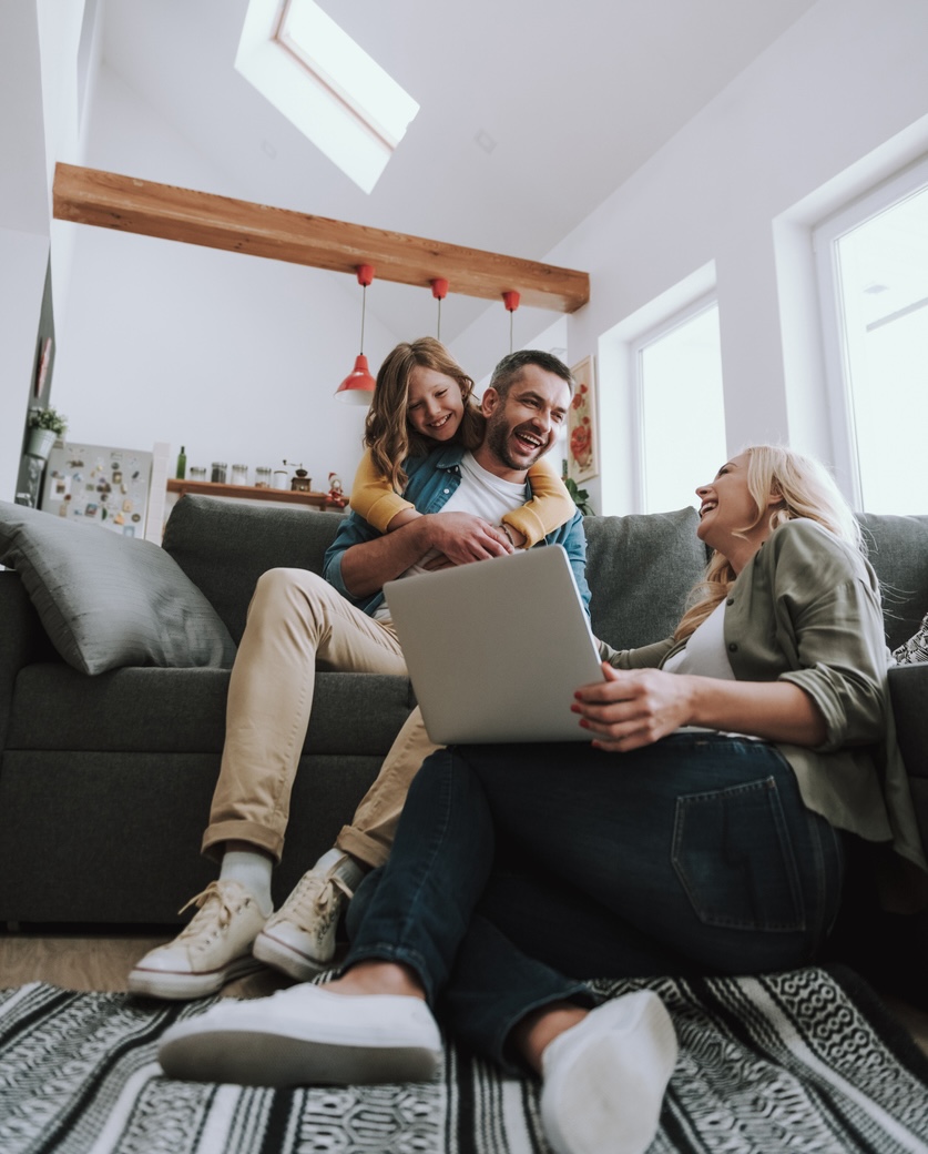 Happy family watching videos on laptop and laughing