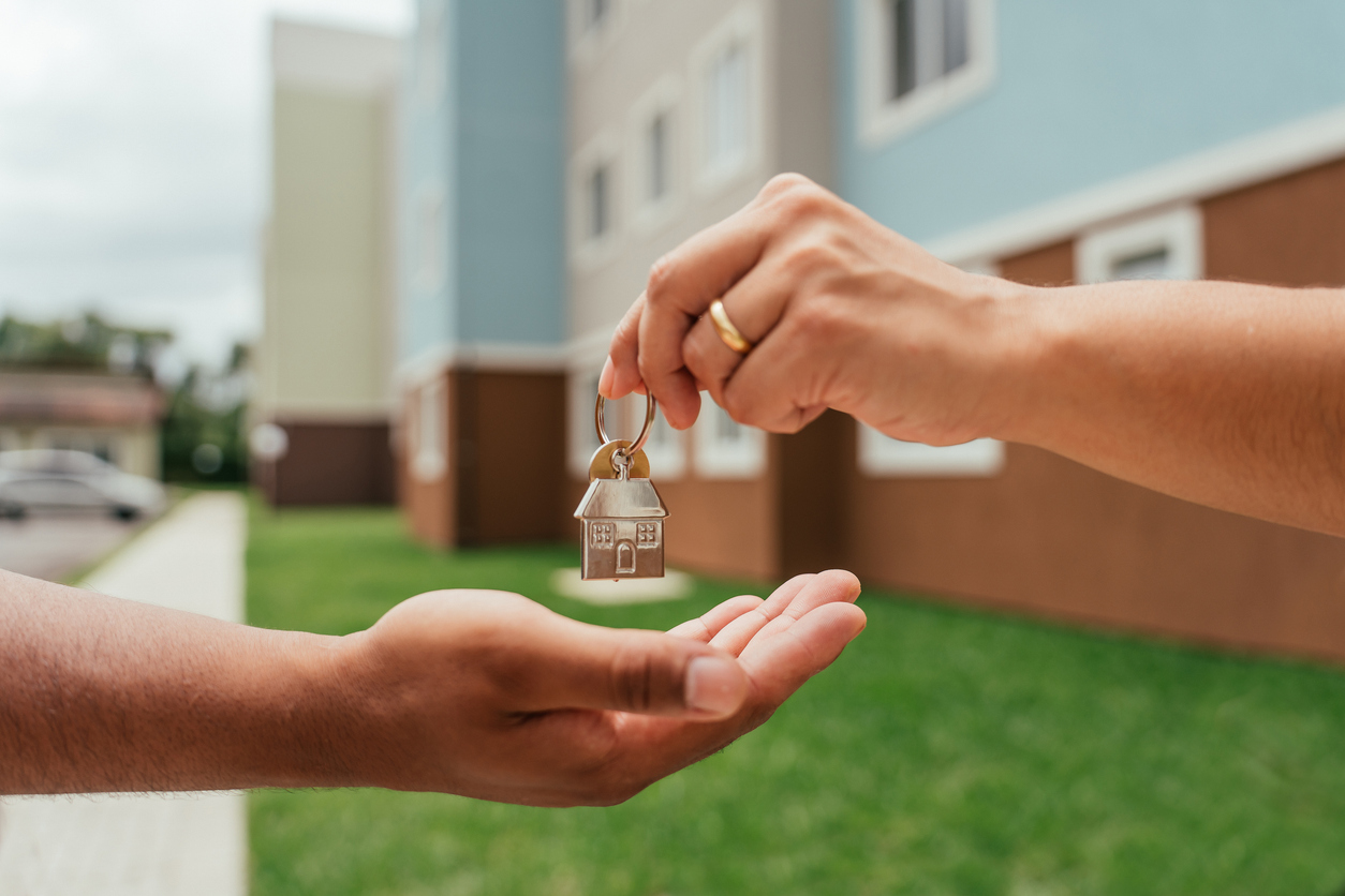 Detail of real estate agent's hands handing over keys Detail of real estate agent's hands handing over keys