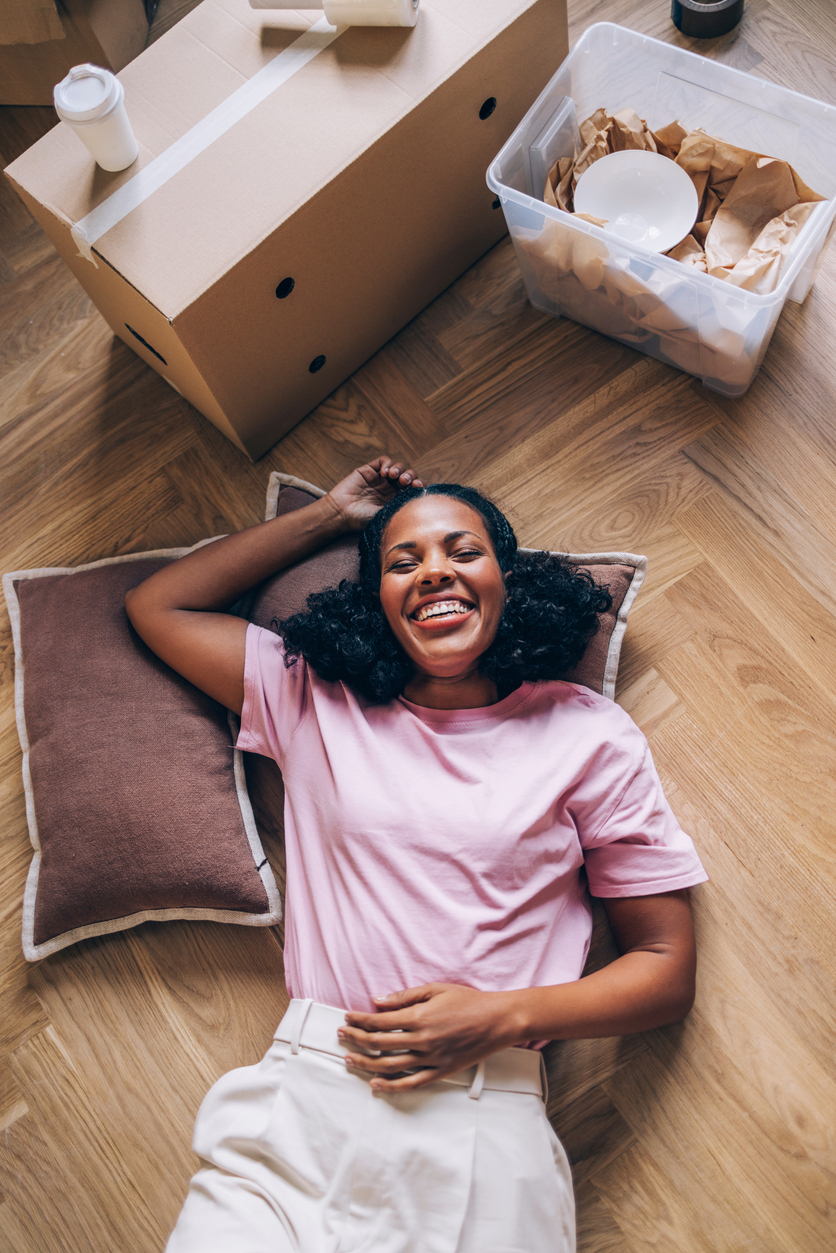 A woman embraces new beginnings, unpacking boxes and transforming her fresh apartment into a space of comfort.