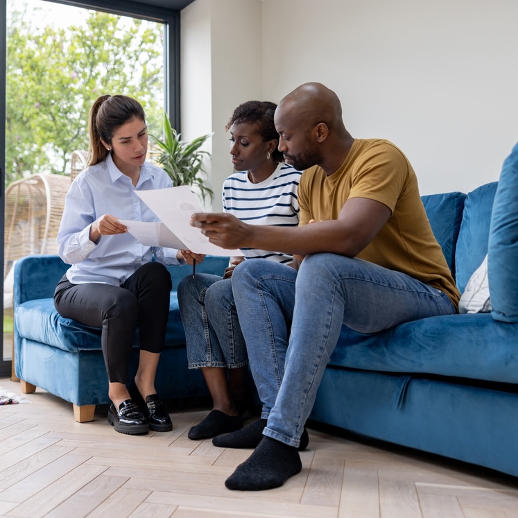 Couple buying a house and reviewing the contract with their real estate agent Couple buying a house and reviewing the contract with their real estate agent